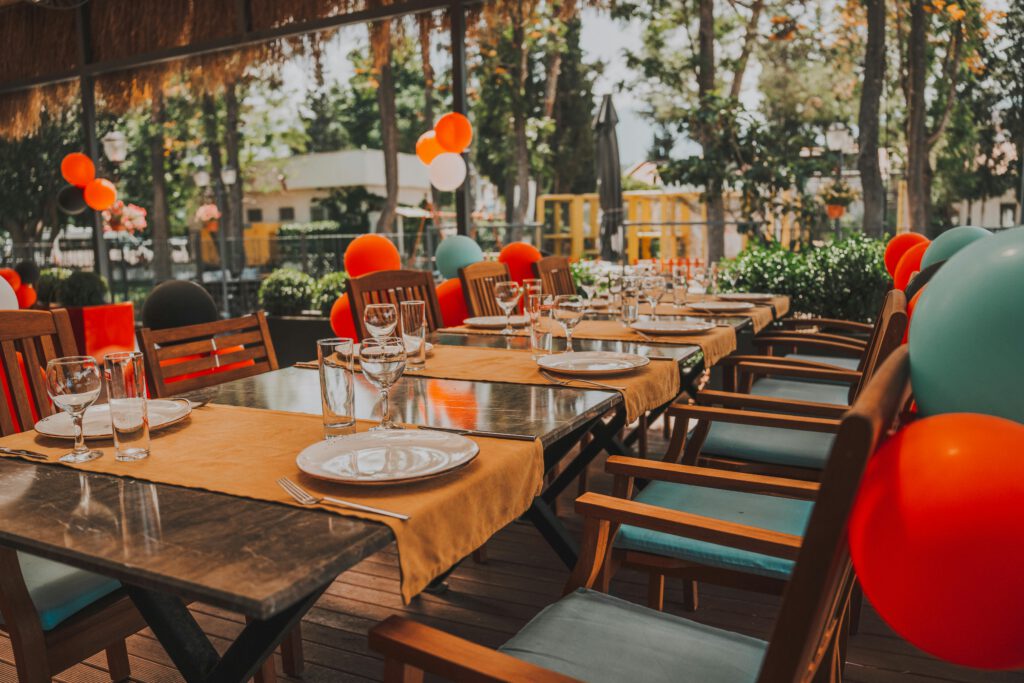 pexels-photo-16930510-16930510 Outdoor table set for a celebration, adorned with colorful balloons creating a festive mood.