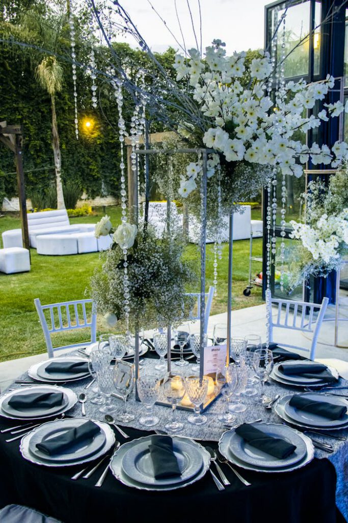 pexels-photo-19655362 Luxurious outdoor table setup with elegant floral arrangements for a sophisticated garden party.