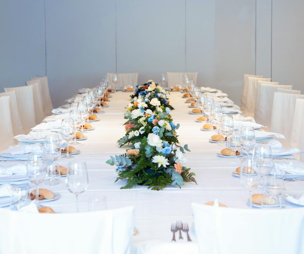 ours-journey Luxurious banquet table setting with a vibrant floral centerpiece, ready for an elegant indoor event.